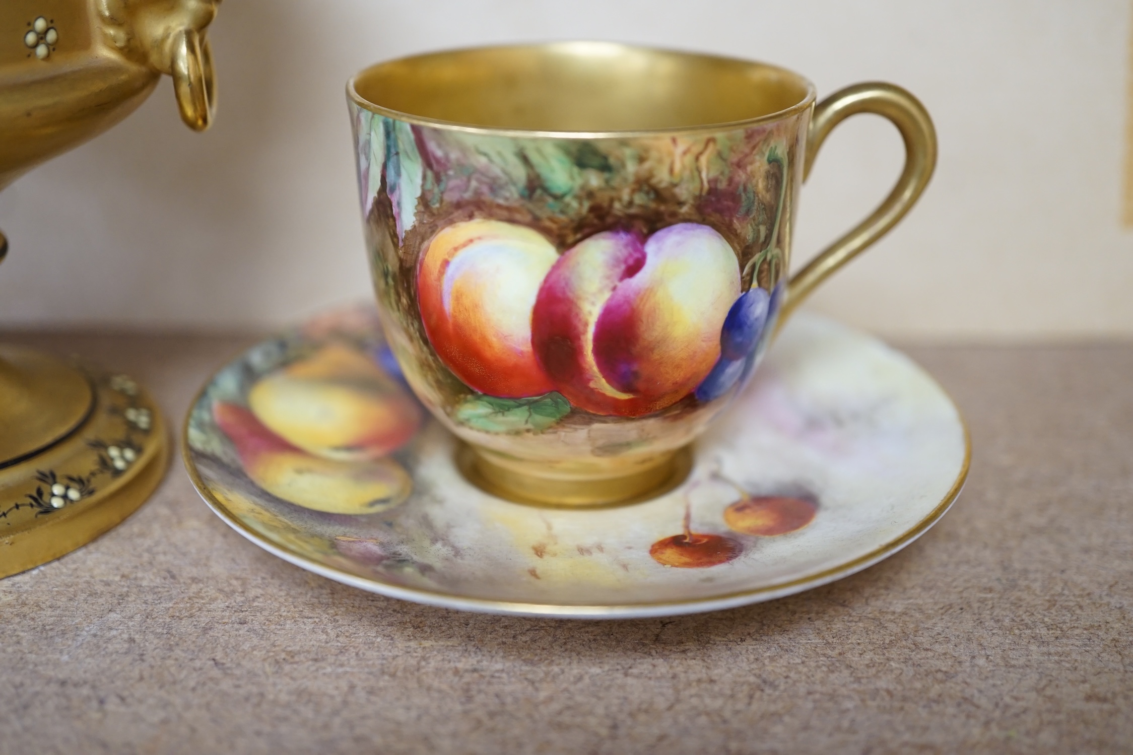 A Royal Worcester miniature fruit painted cup and saucer, Hale and Everett, and an unusual gilded campana vase, 10cm high. Condition - saucer cracked, otherwise good